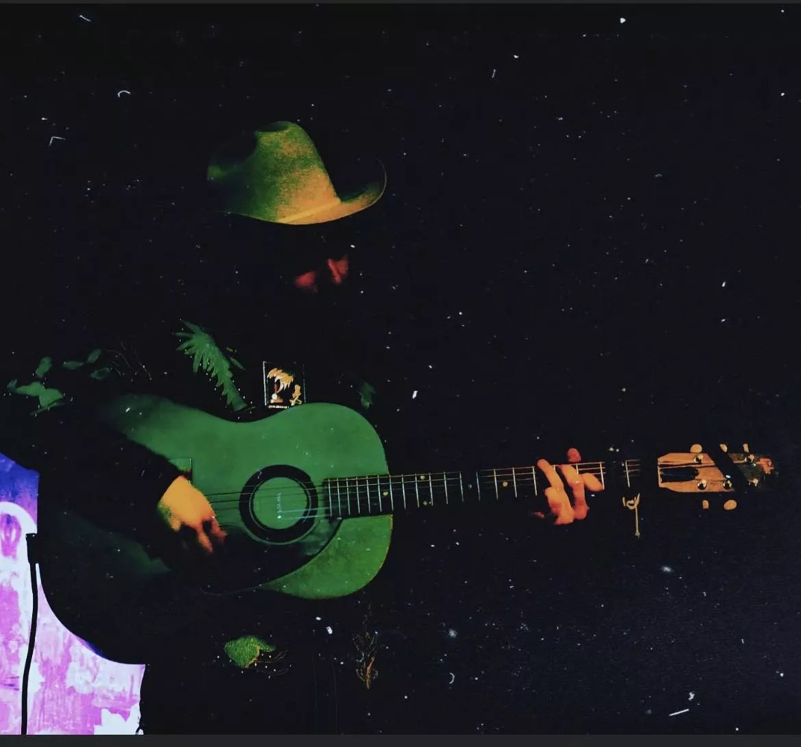man in cowboy hat playing guitar