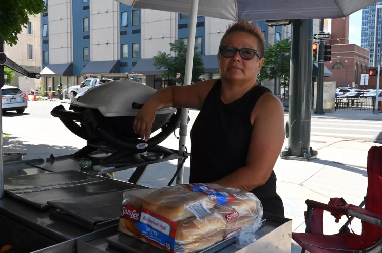 Marcella Armas stands at her hot dog cart by Denver City Hall.