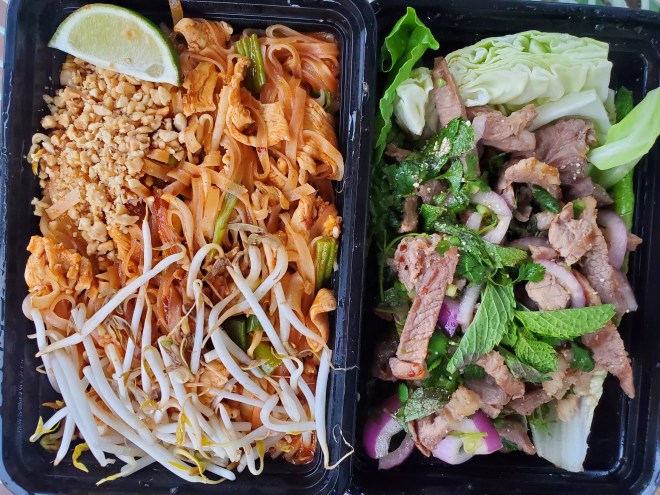 two to-go boxes open and filled with food