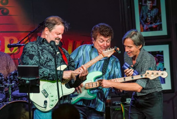 three men playing guitar