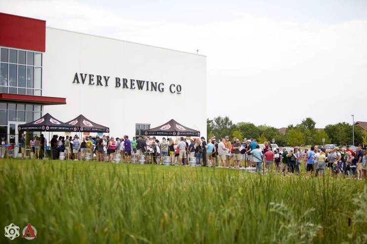 people standing around tents outside a large white building