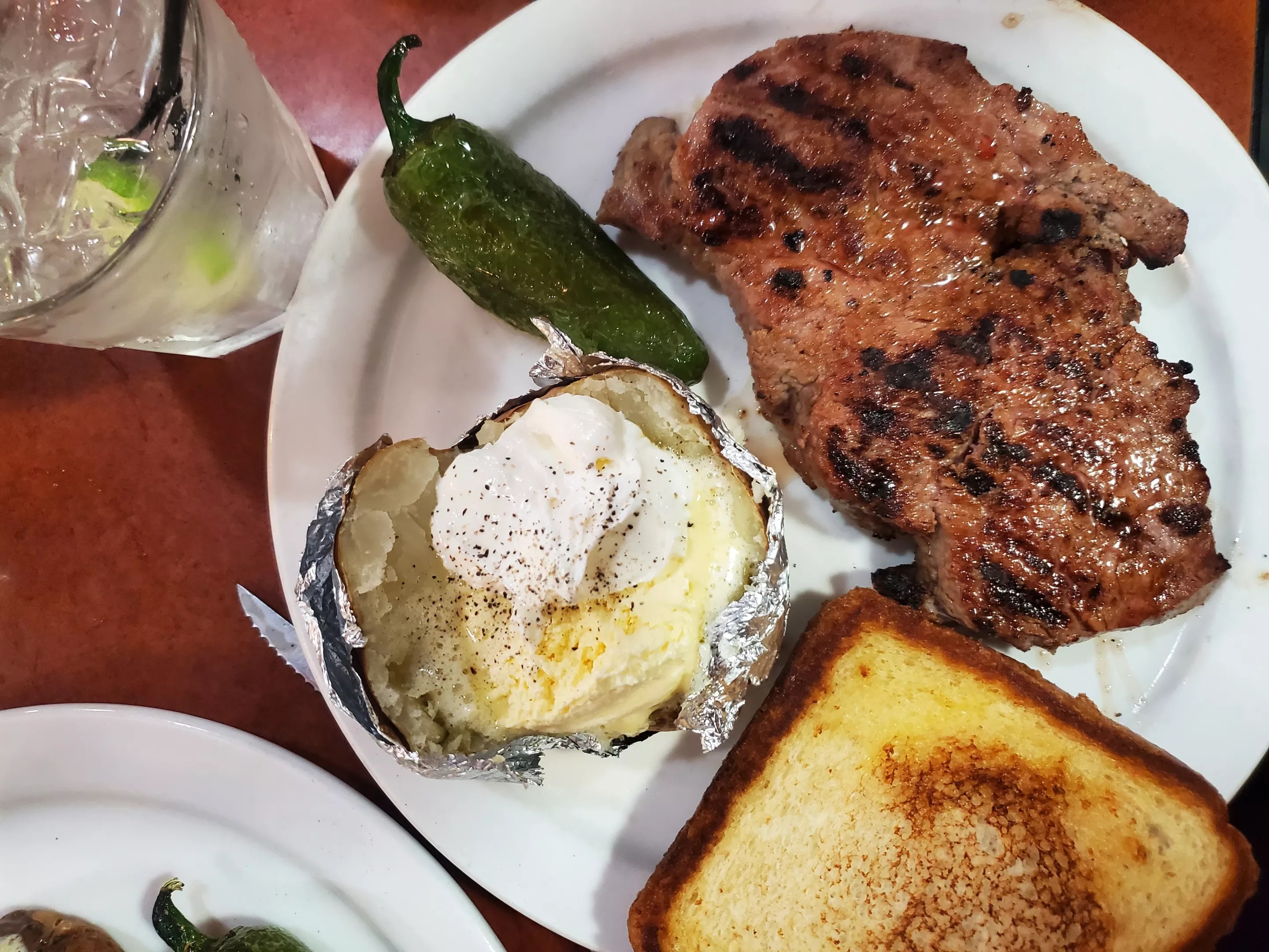 baked potato, jalapeno, toast and a steak