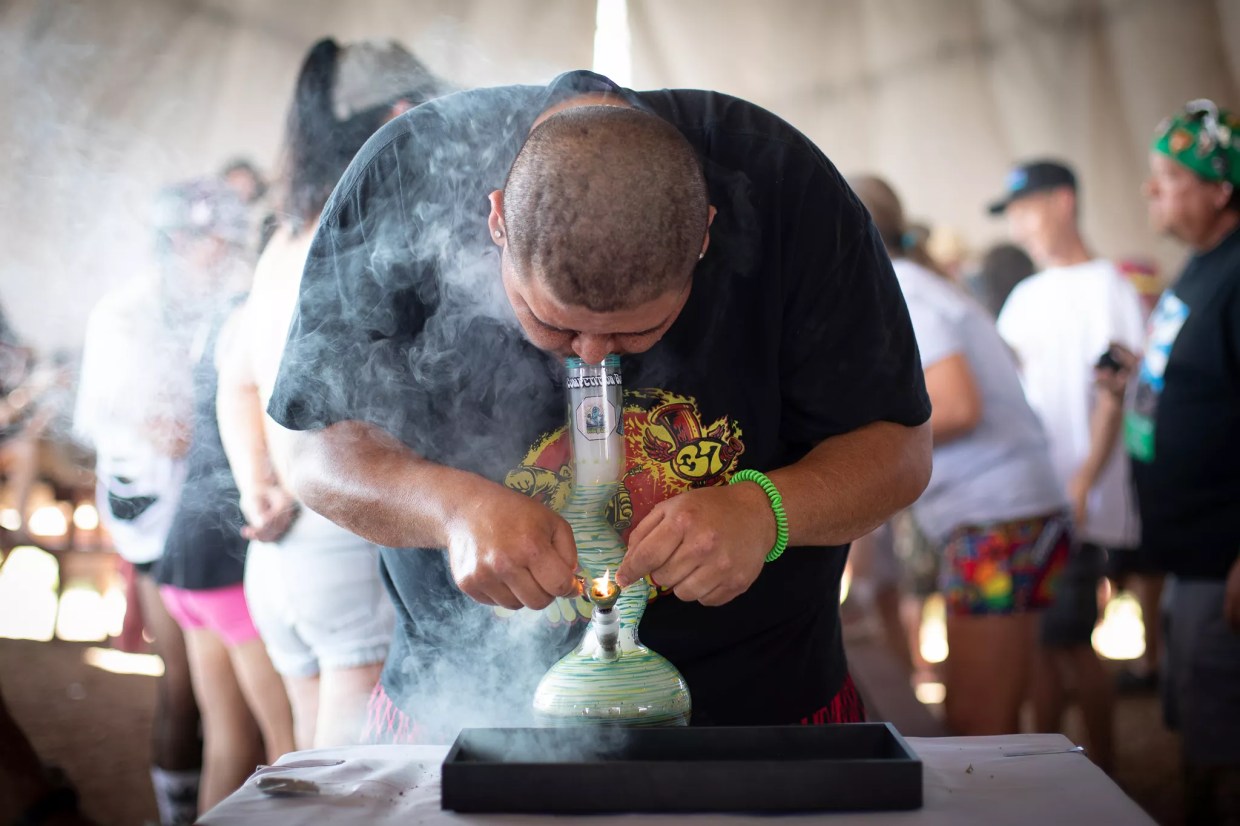 A man hits weed from a bong