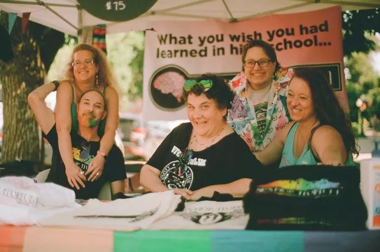 women laughing at a booth