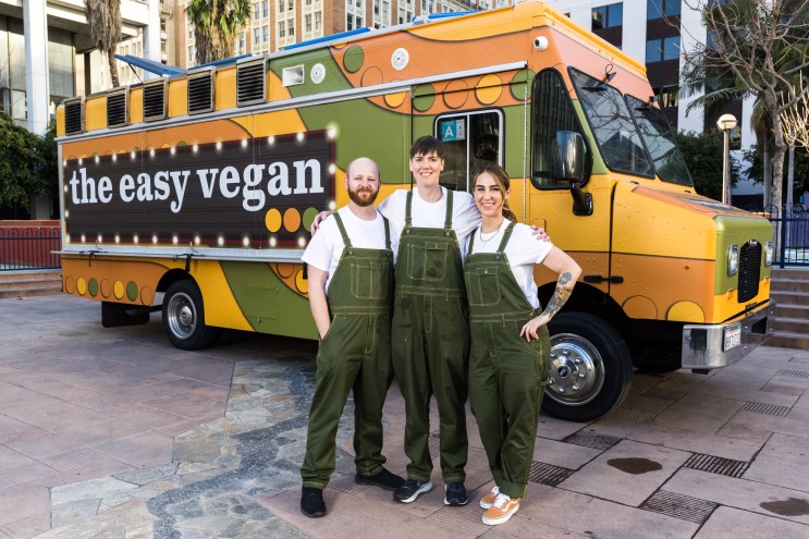 Three people in front of a food truck
