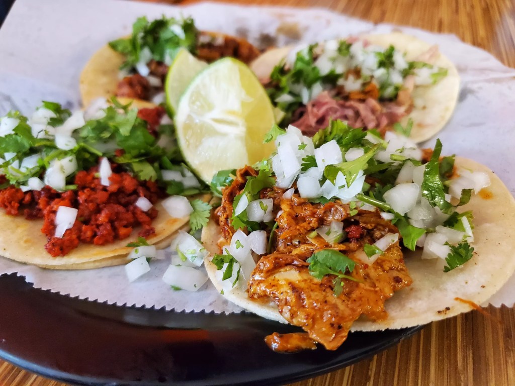 tacos on a plate with a slice of lime