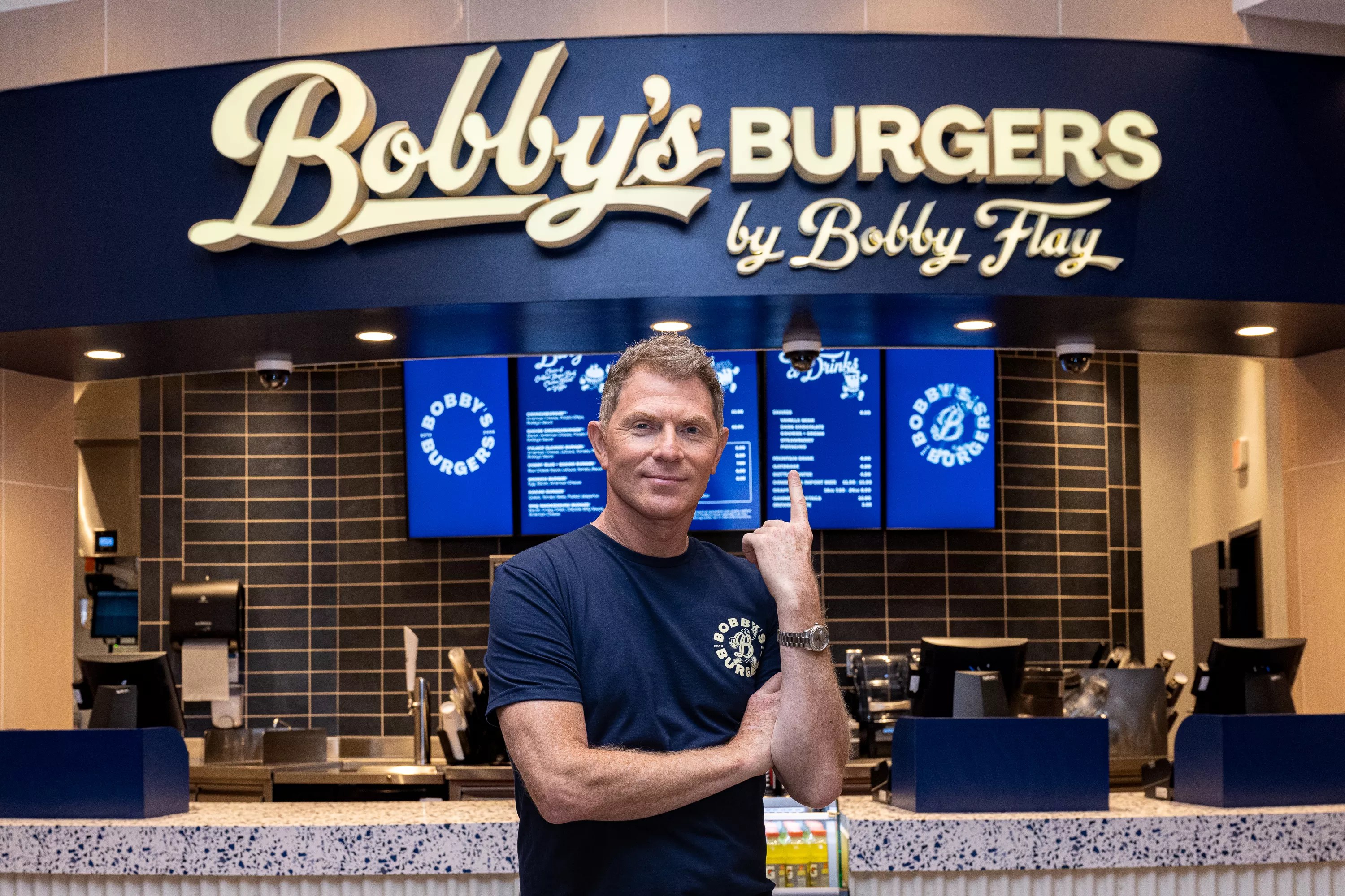 a man stands in front of a sign inside a restaurant