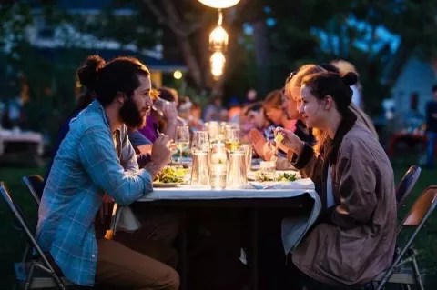 people sitting at a dining table outside