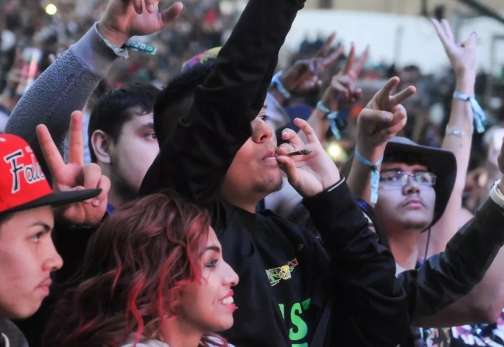 A concert goer smokes a joint outdoors