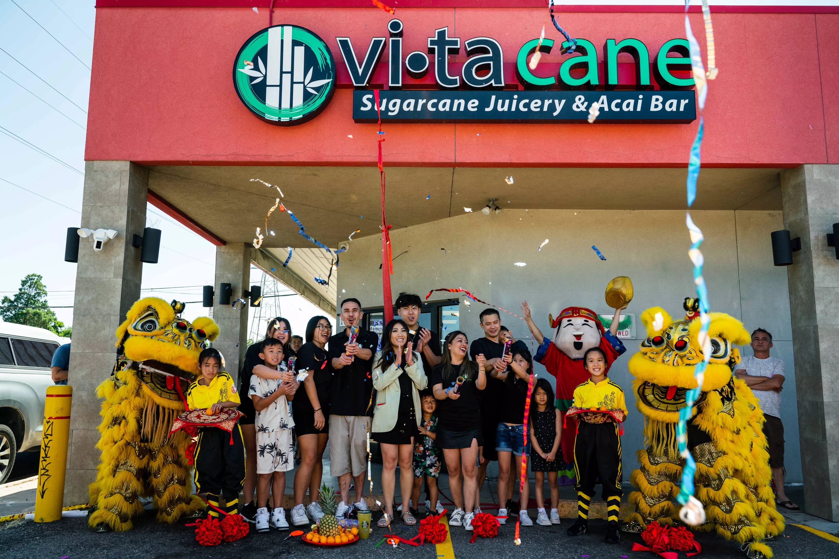 a group of people in front of a storefront with dragon dancers.