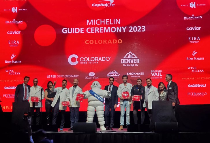 people standing on a stage in front of a red background
