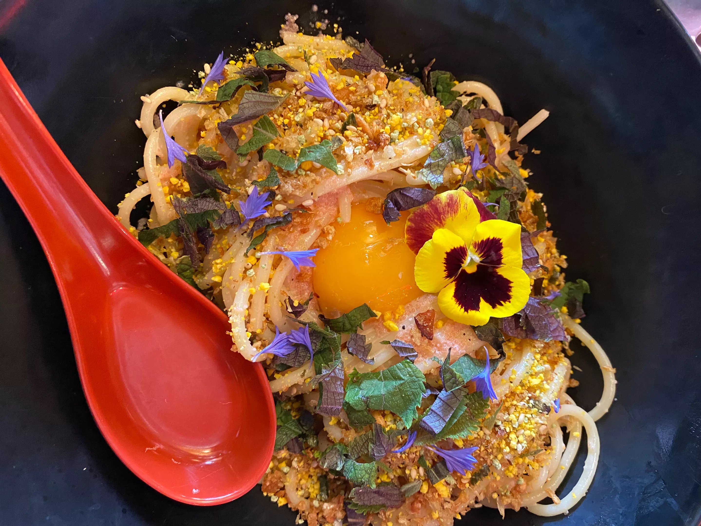 a spaghetti dish with an egg yolk
