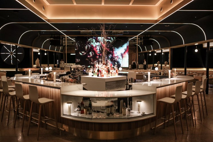 a bar and dining room with black and gold accents
