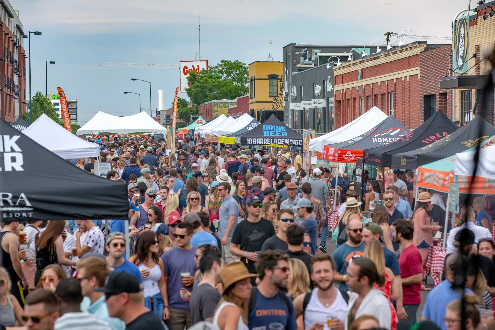 Crowded street with several tents.