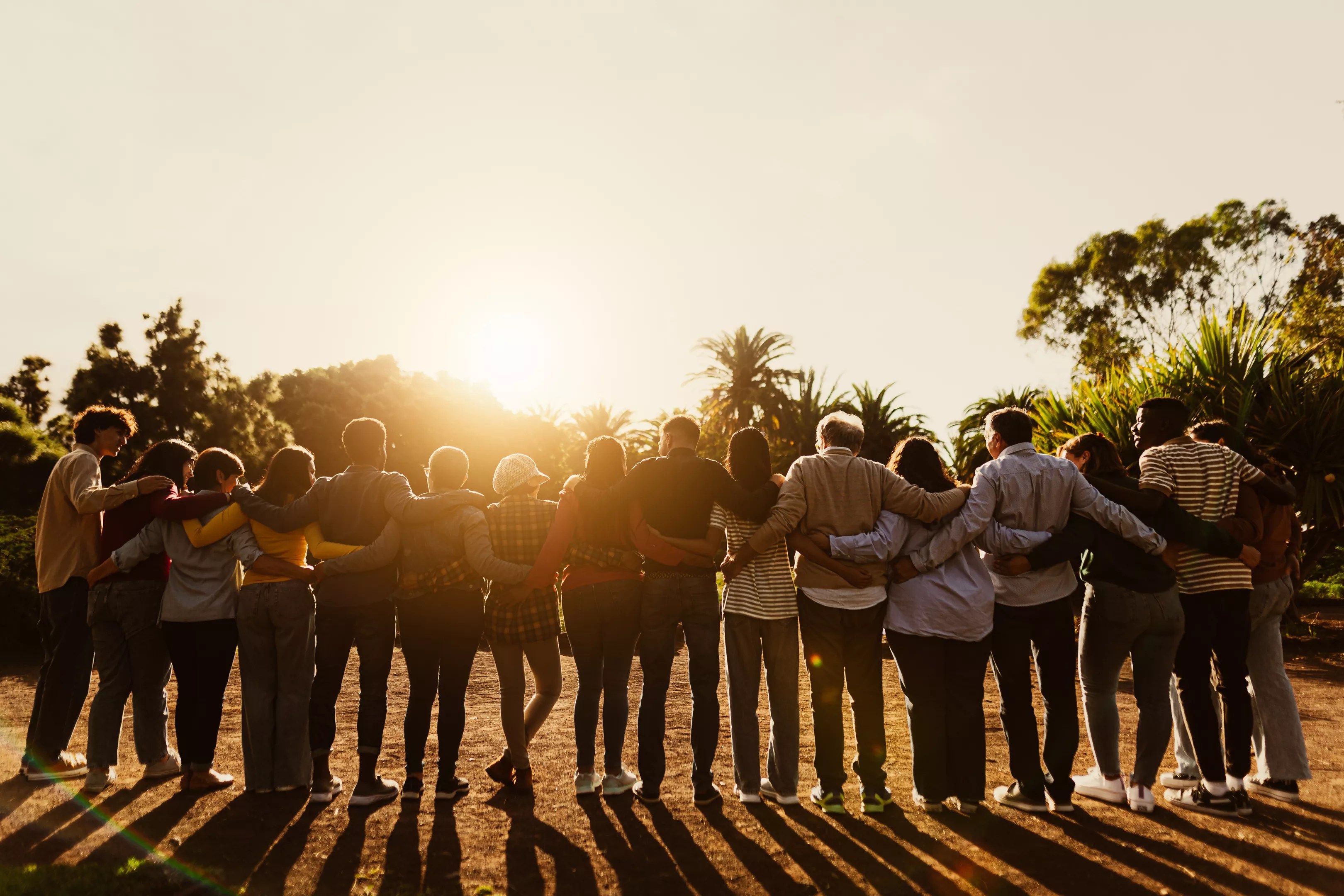 group of people hugging at sunrise