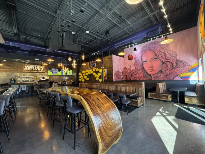 a large wooden table inside a restaurant with murals