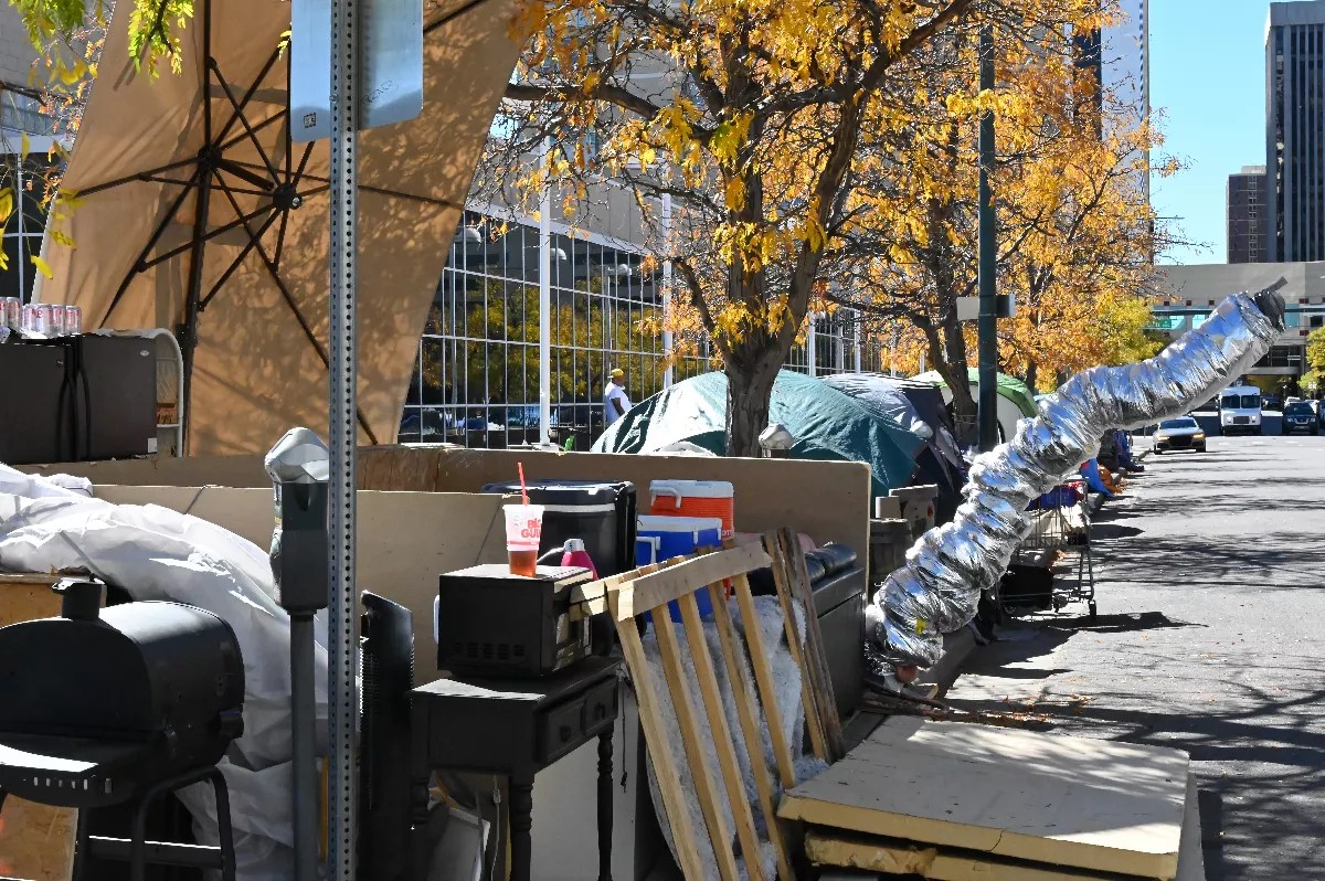A tent in front of the U.S. Post Office has a makeshift stove pipe sticking out.