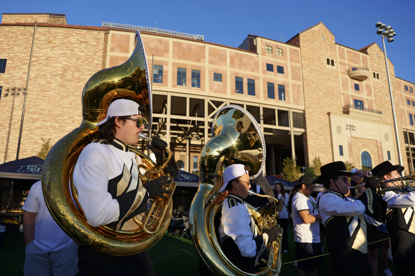 People wearing black and white play the tuba.