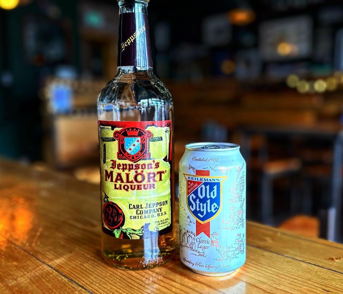 a bottle of liquor next to a can of beer