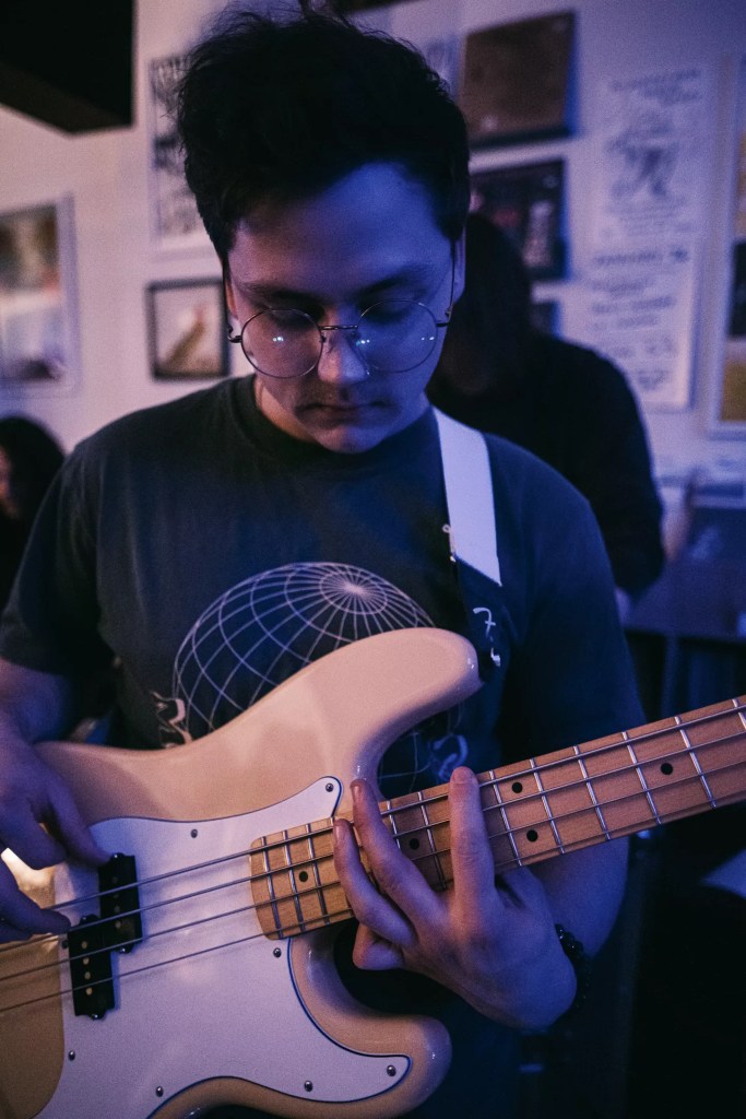 man with glasses holding a bass