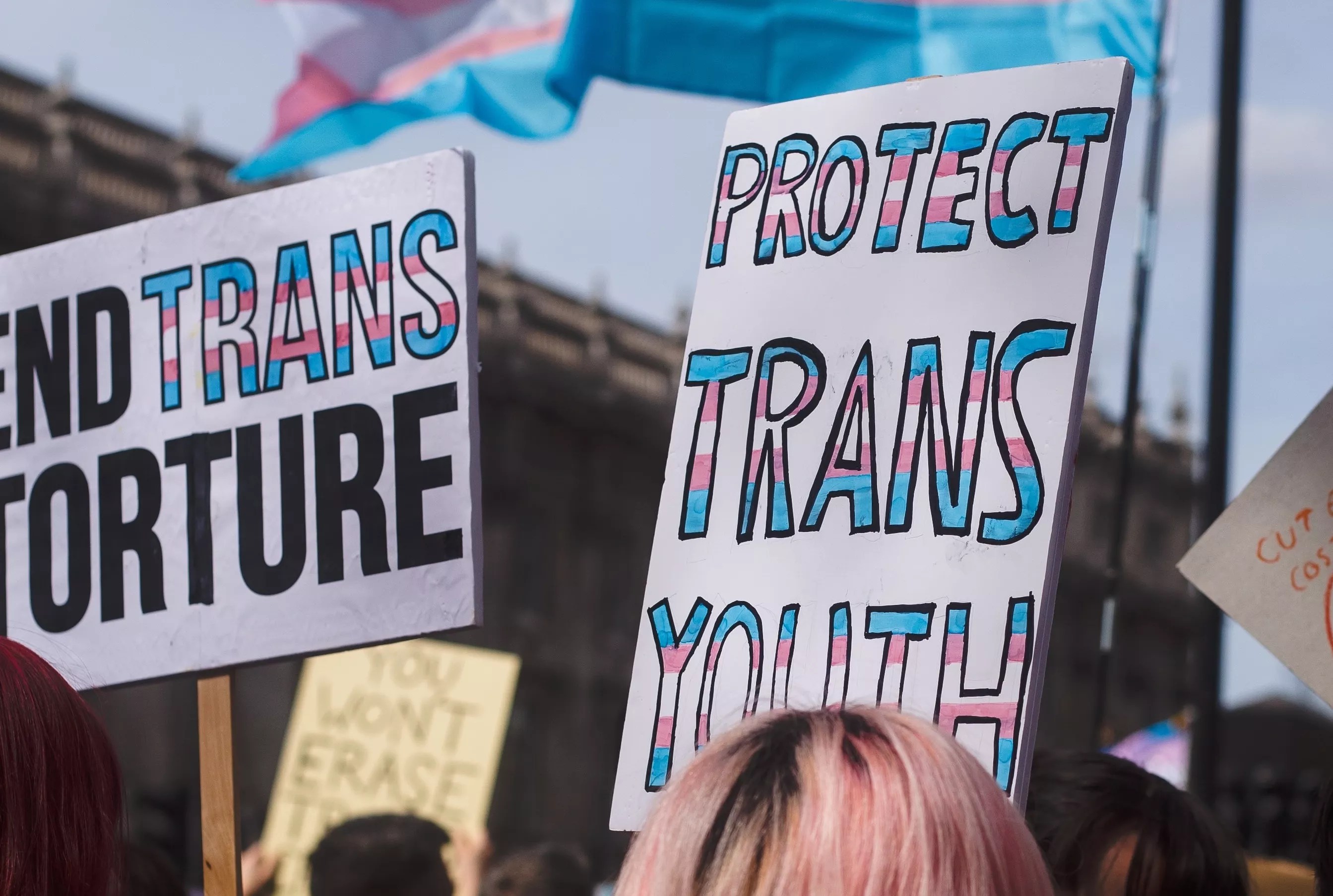 A protester holds a sign that says "protect trans youth."