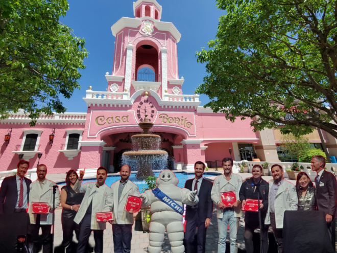photoshopped group of people in front of a pink building