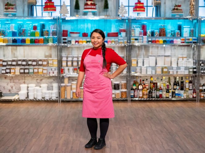 a woman posting in a red shirt and pink apron