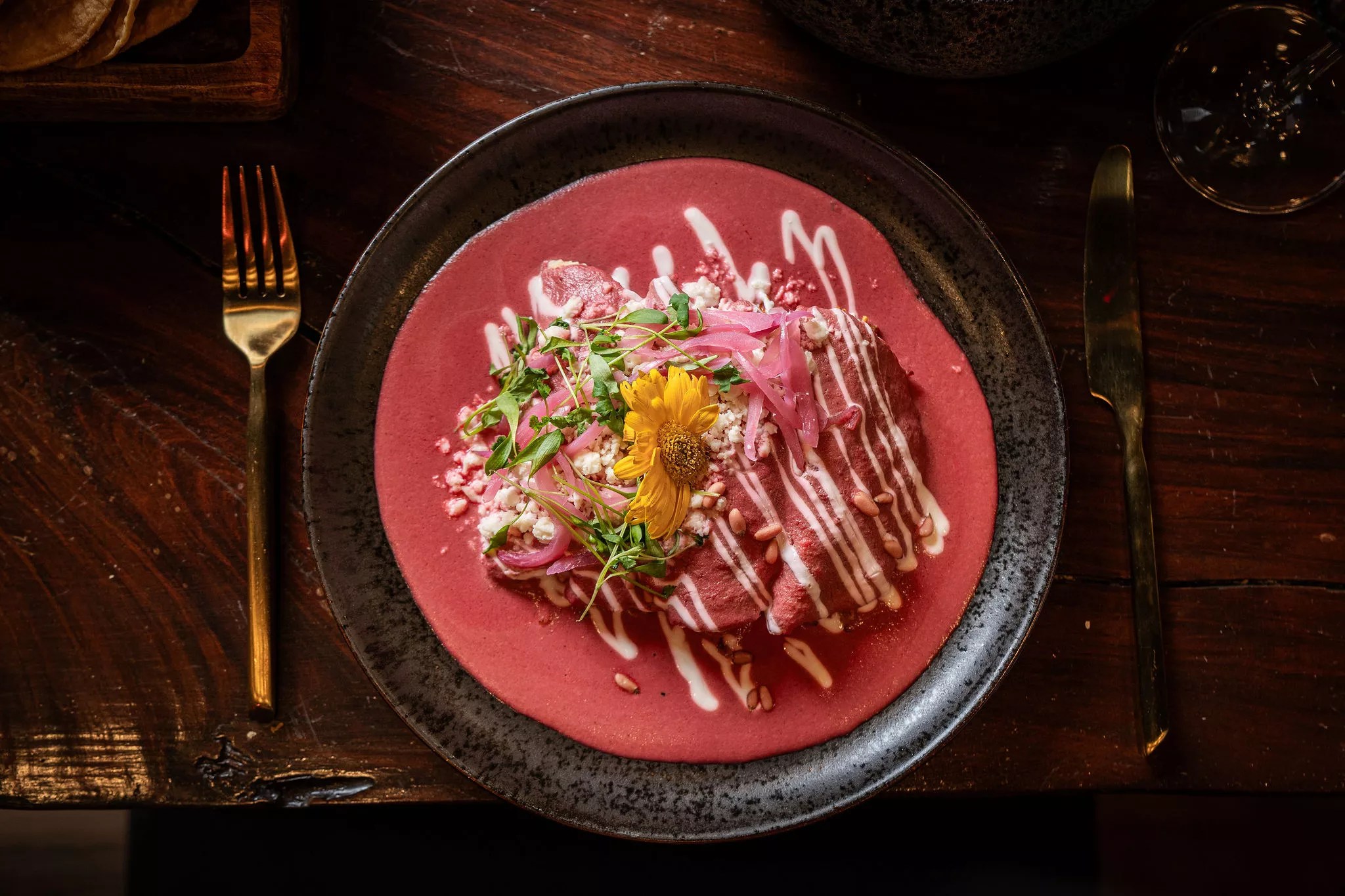 a dish with pink sauce on a black plate