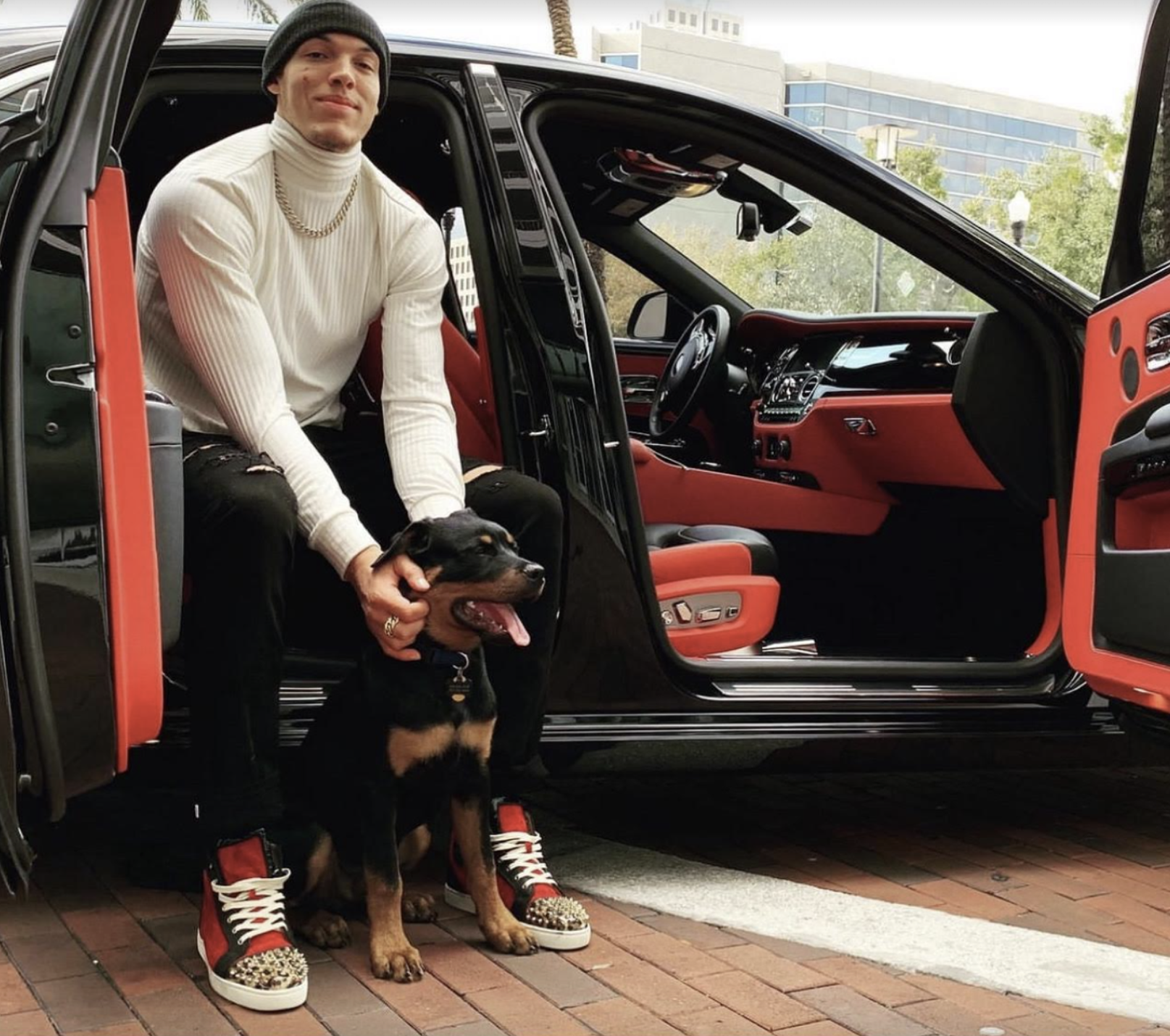 Denver Nuggets player Aaron Gordon posing with his Rottweiler for a picture.
