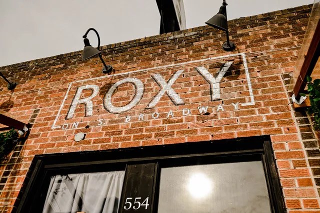 sign on brick building reading Roxy