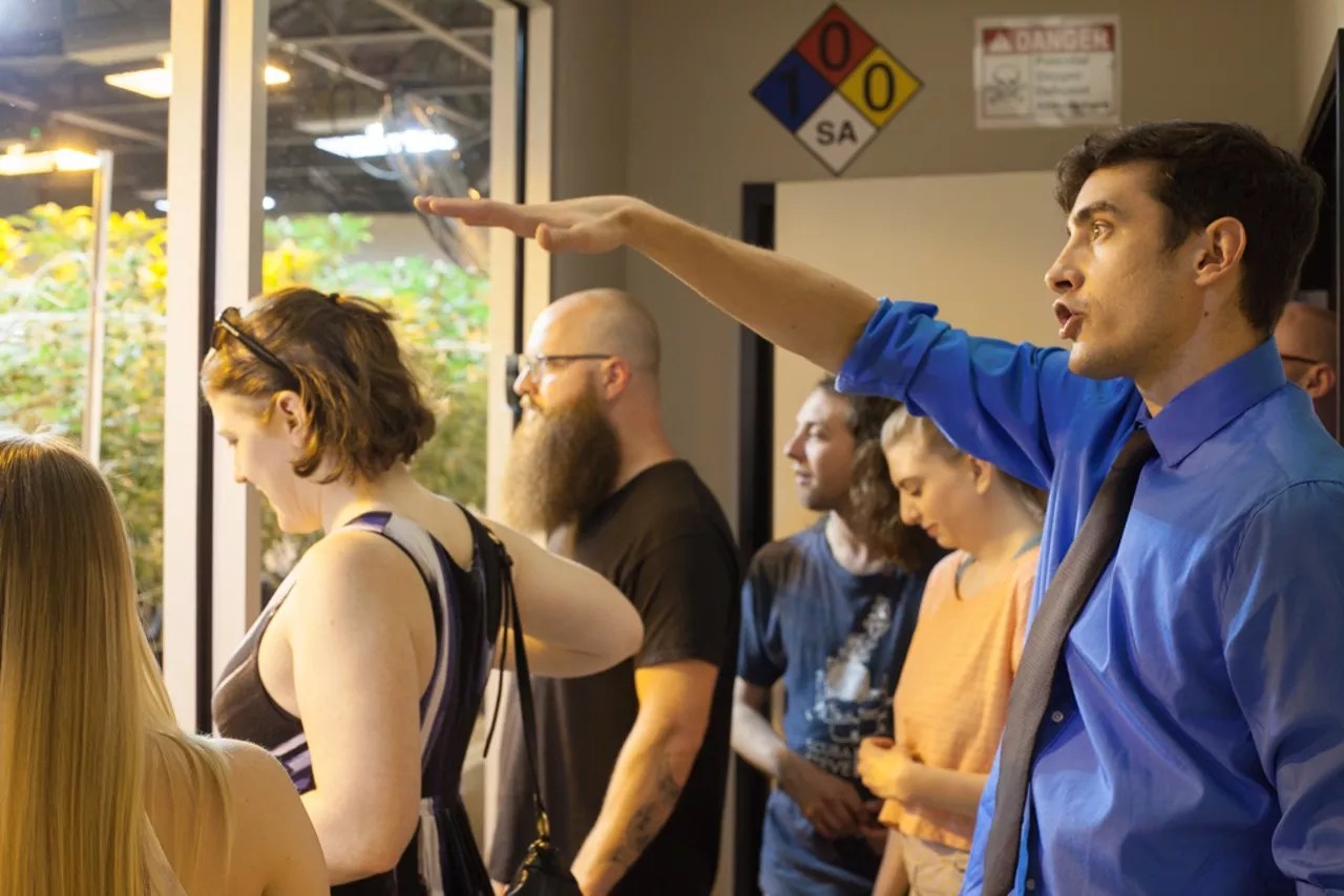 A man points out marijuana plants during a cannabis grow tour