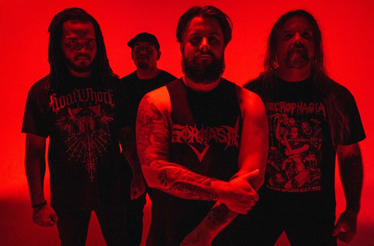 bandmates pose for photo in red lighting