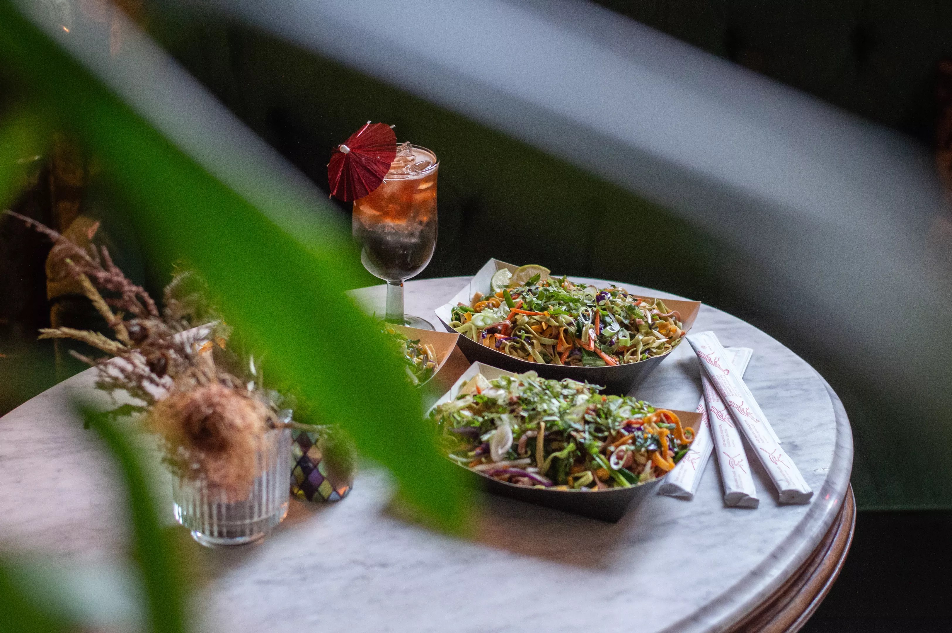 two plates of food and a cocktail on a table