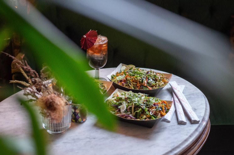 two plates of food and a cocktail on a table
