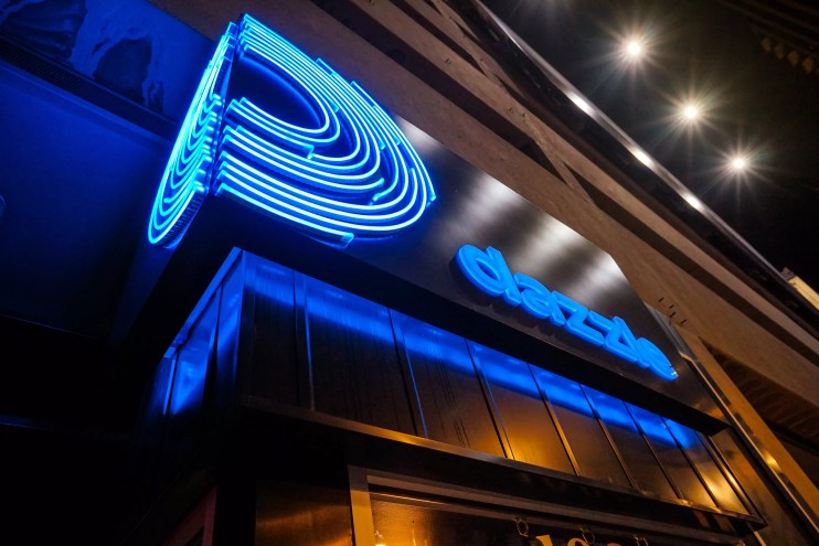 a sign that reads "Dazzle" in neon blue.