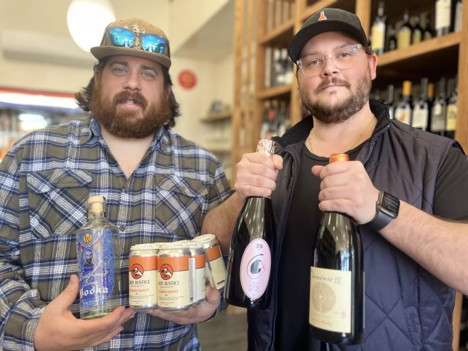 two men holding bottles of wine and cans of beer