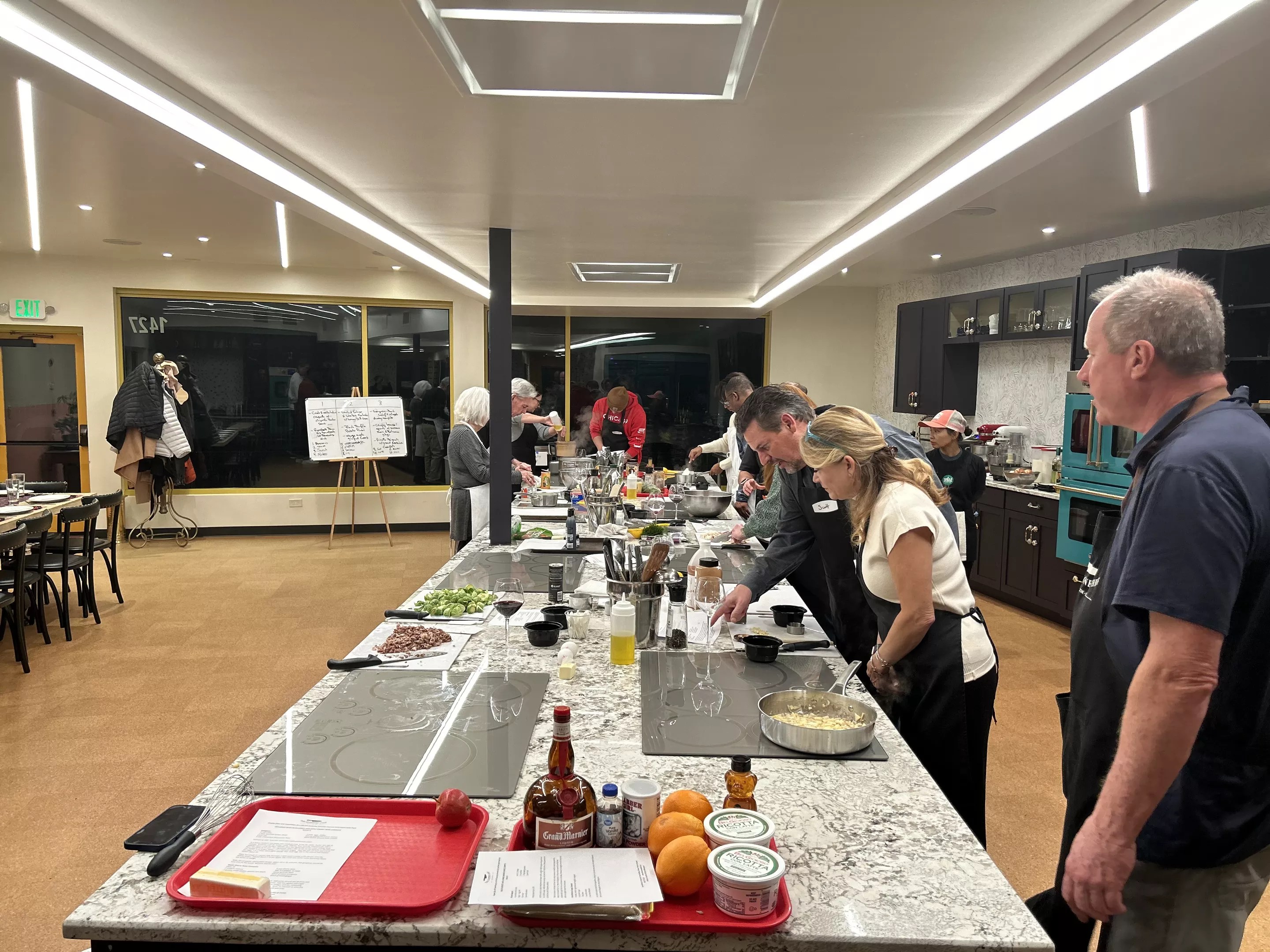 people in aprons standing around a long counter