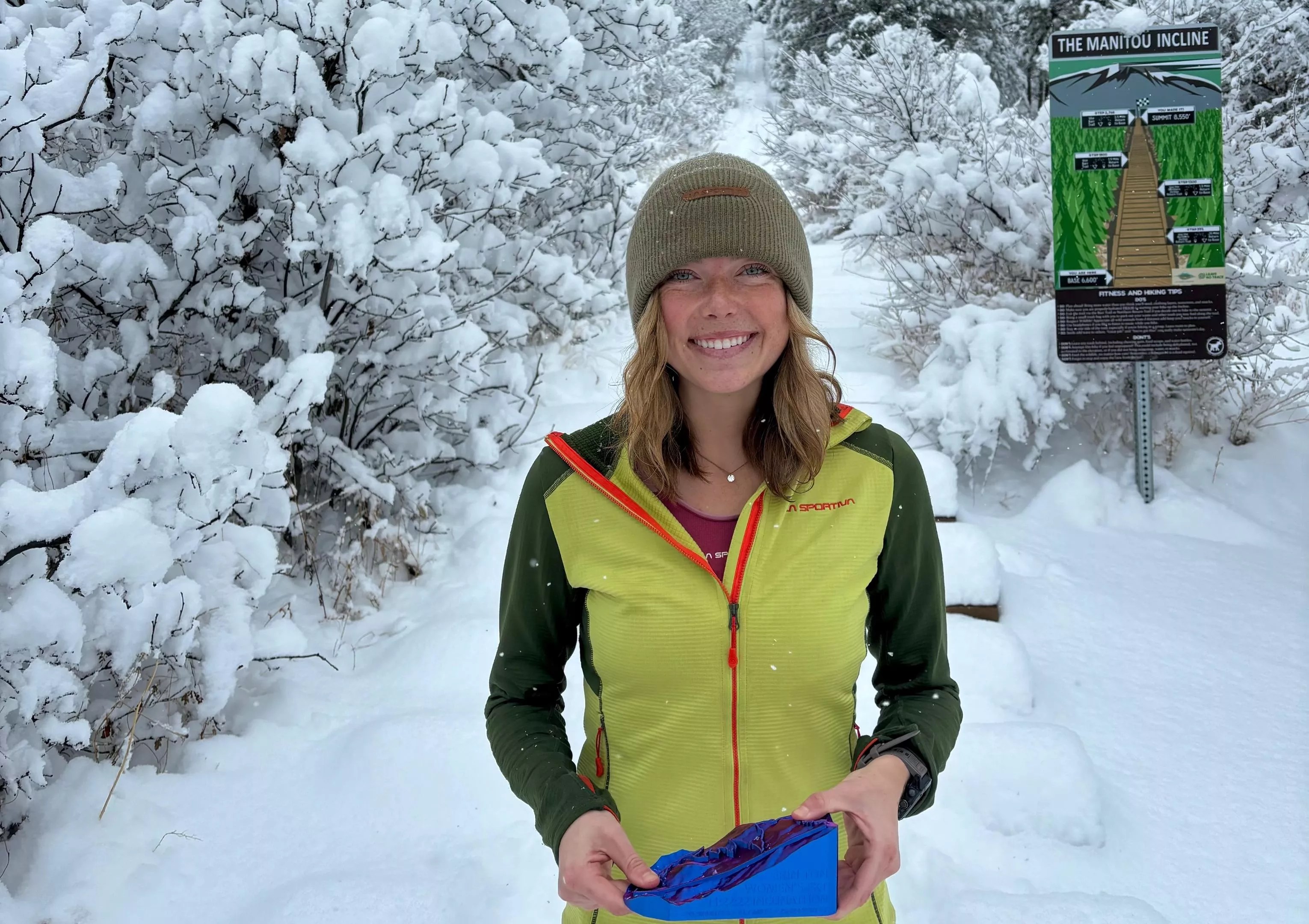 Erin Ton posing with a trophy at the base of the Manitou Incline after her record-breaking run.