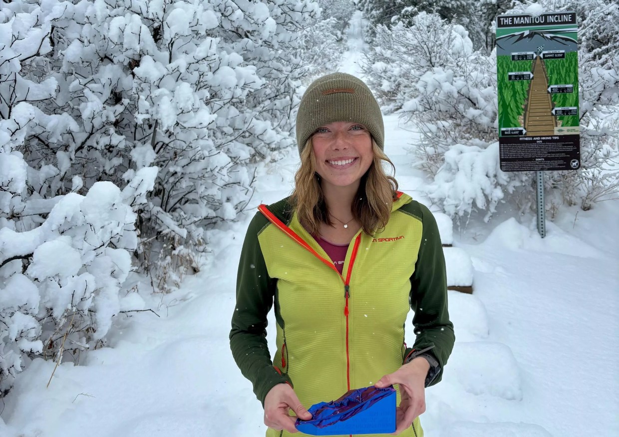 Erin Ton posing with a trophy at the base of the Manitou Incline after her record-breaking run.