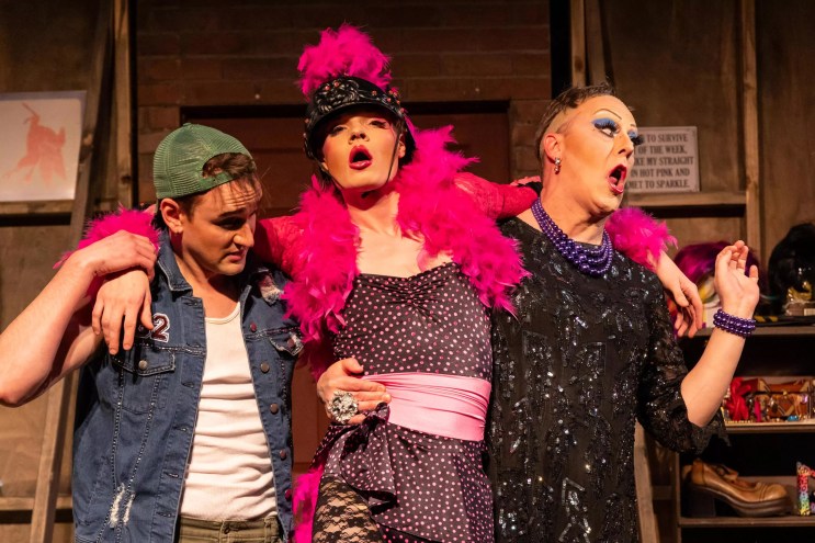 man with blue hair, man in pink boa, man in black shirt