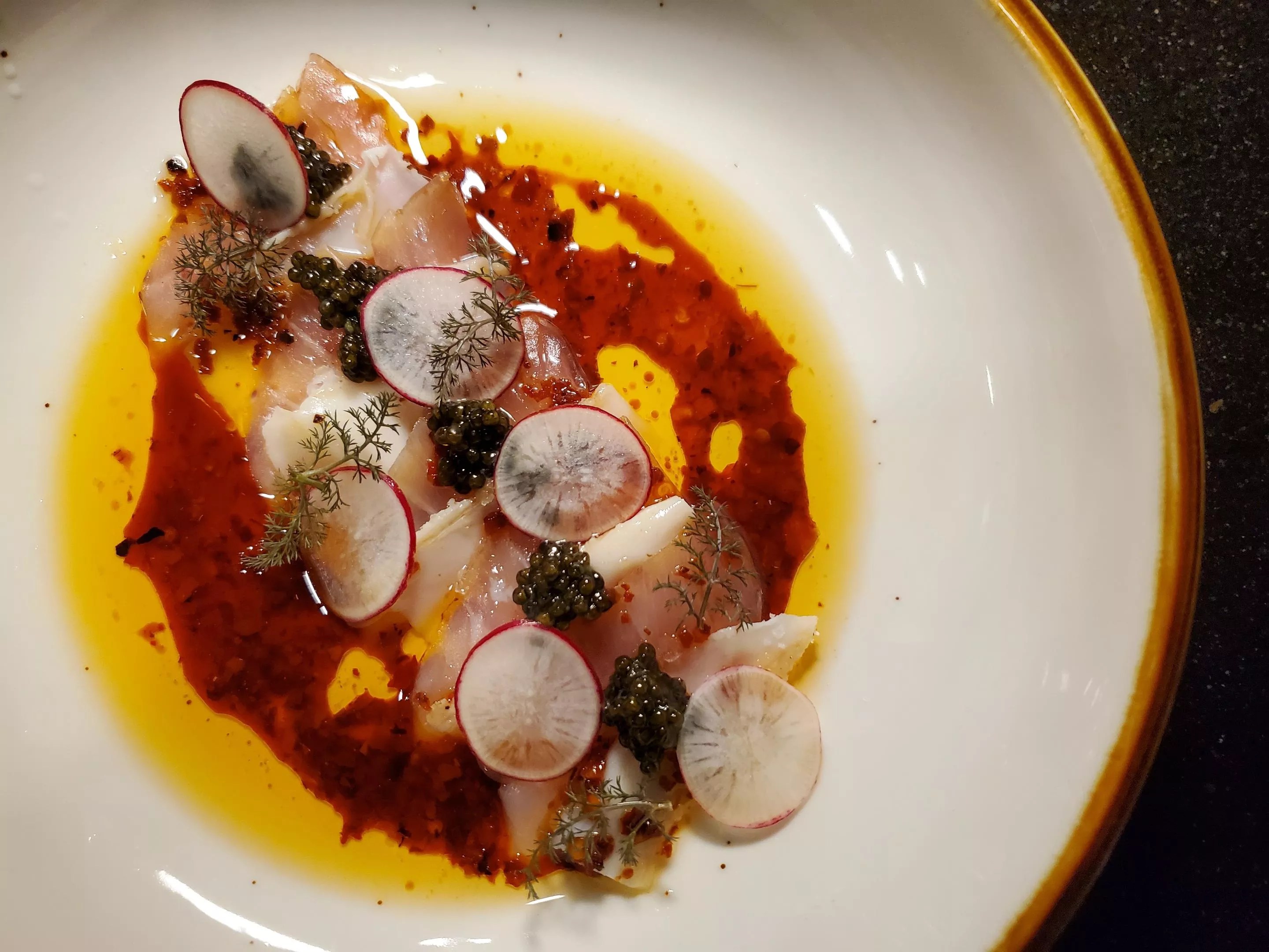 kampachi on a plate with sliced radishes