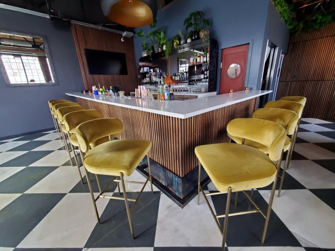 yellow velvet stools surrounding a bar
