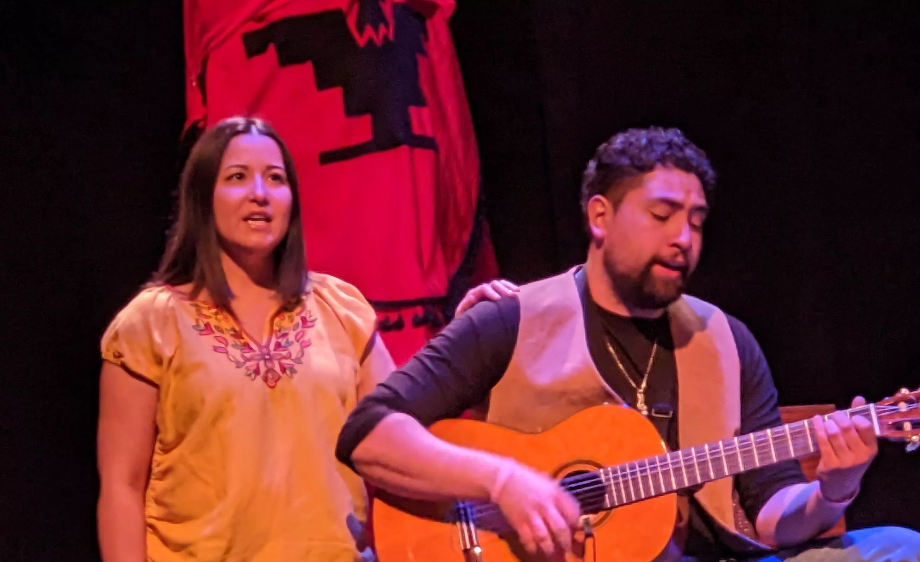 woman in yellow shirt and man playing guitar