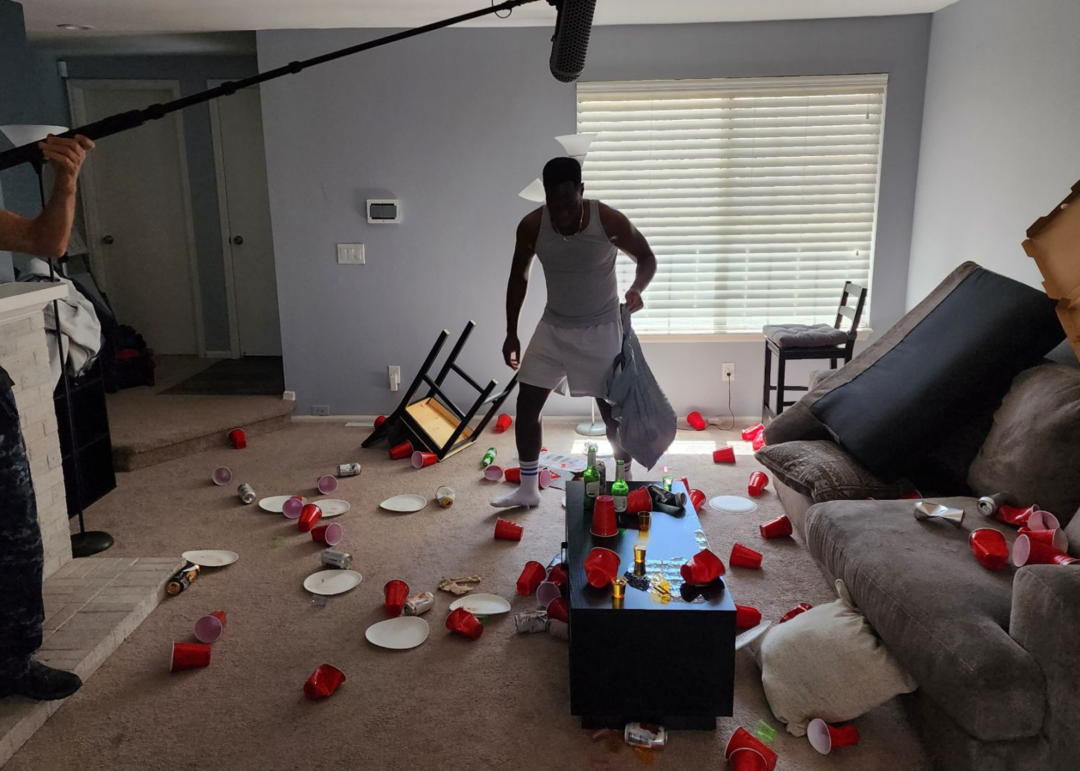 a man stands in a room with solo cups all over the floor