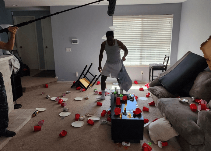 a man stands in a room with solo cups all over the floor