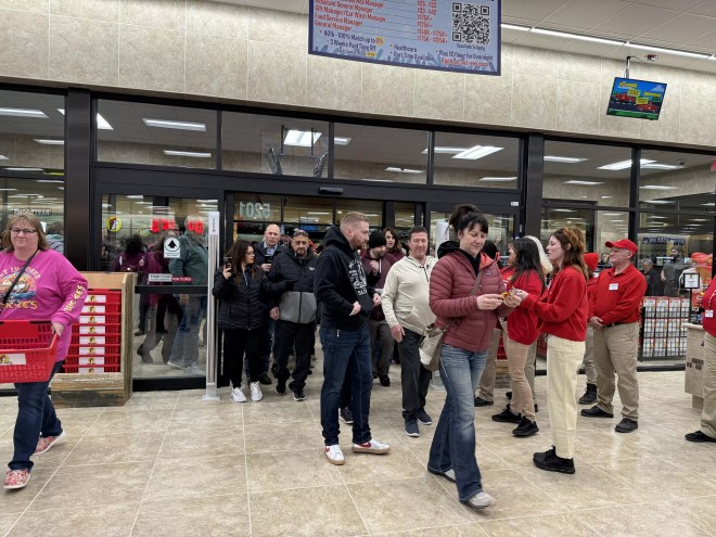 a line of people walking into a store