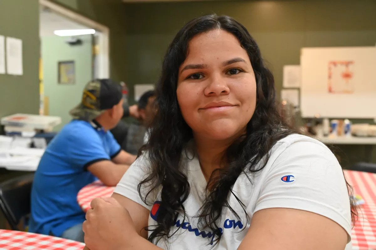 A Venezuelan migrant woman smiles.