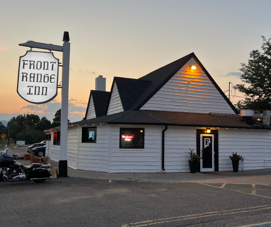 white "front range inn" sign outside a small white building