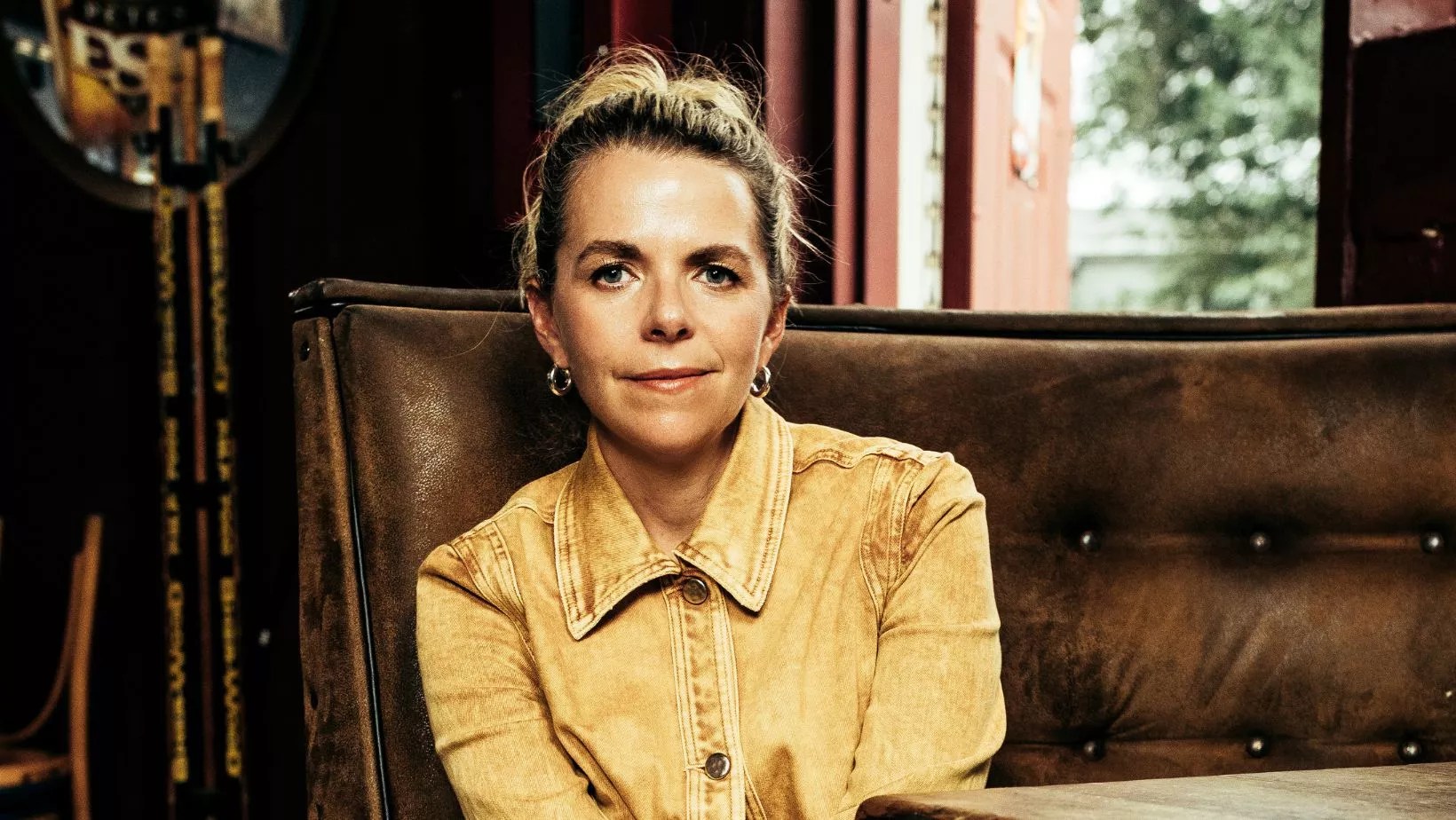 woman smiling in yellow jacket