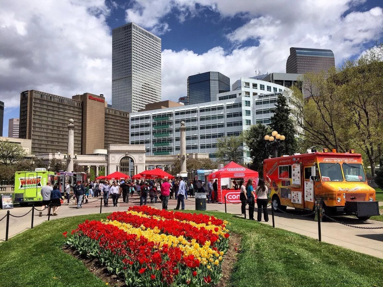 Denver city park with flowers and food trucks.